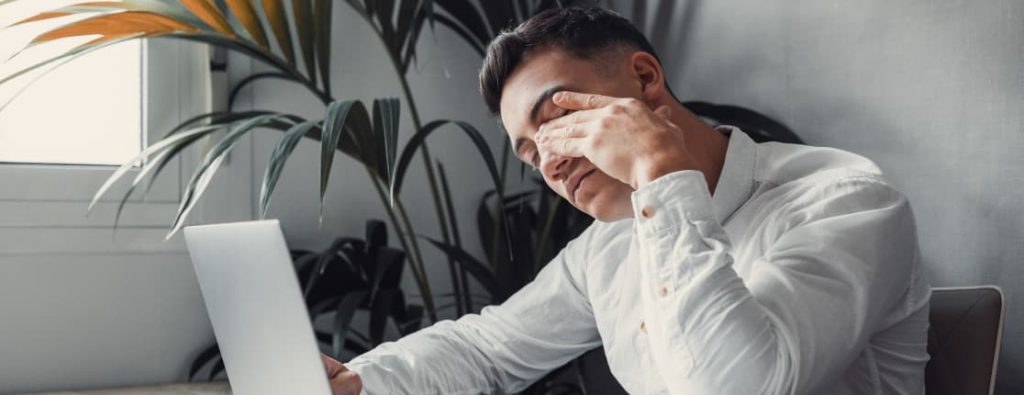 仕事中に疲れやストレスを感じているビジネスパーソンのイメージ。