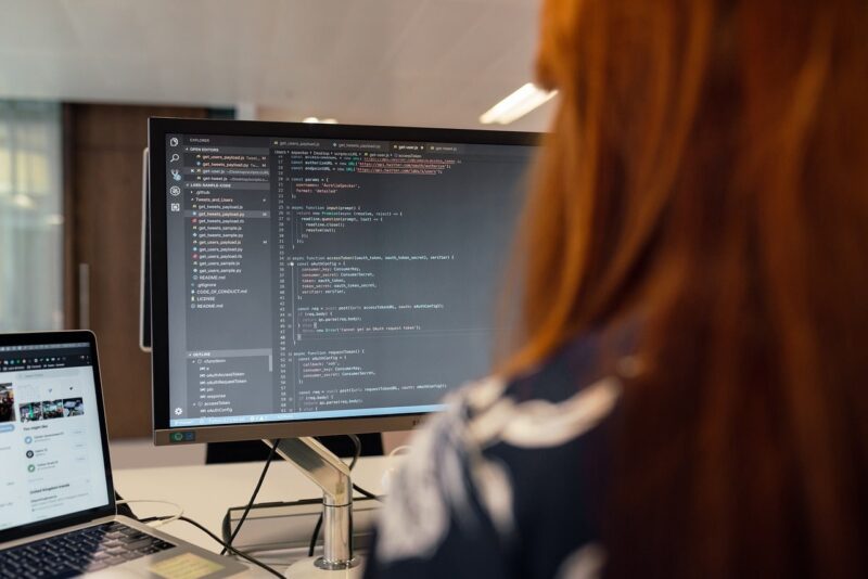 パソコンに向かってコードを書く女性