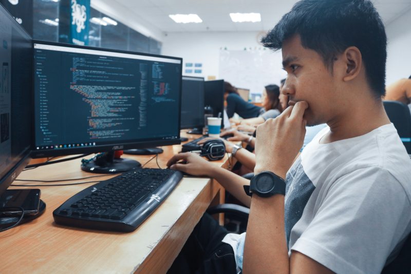 PC画面を見つめながら黙々と作業する男性エンジニアの様子