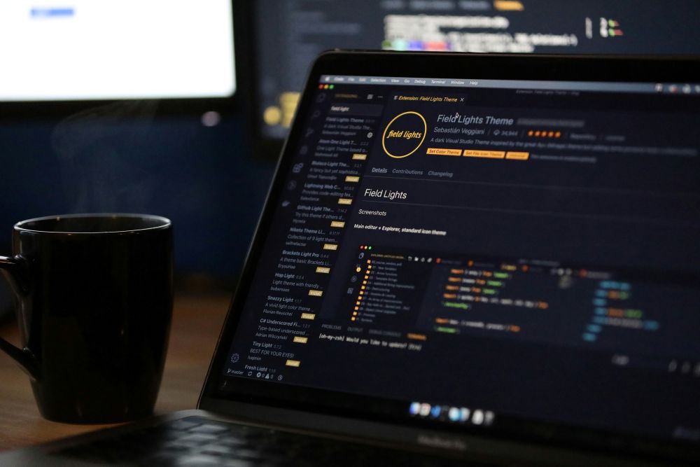 コーディング画面を見ながら静かに作業するエンジニアのデスク風景