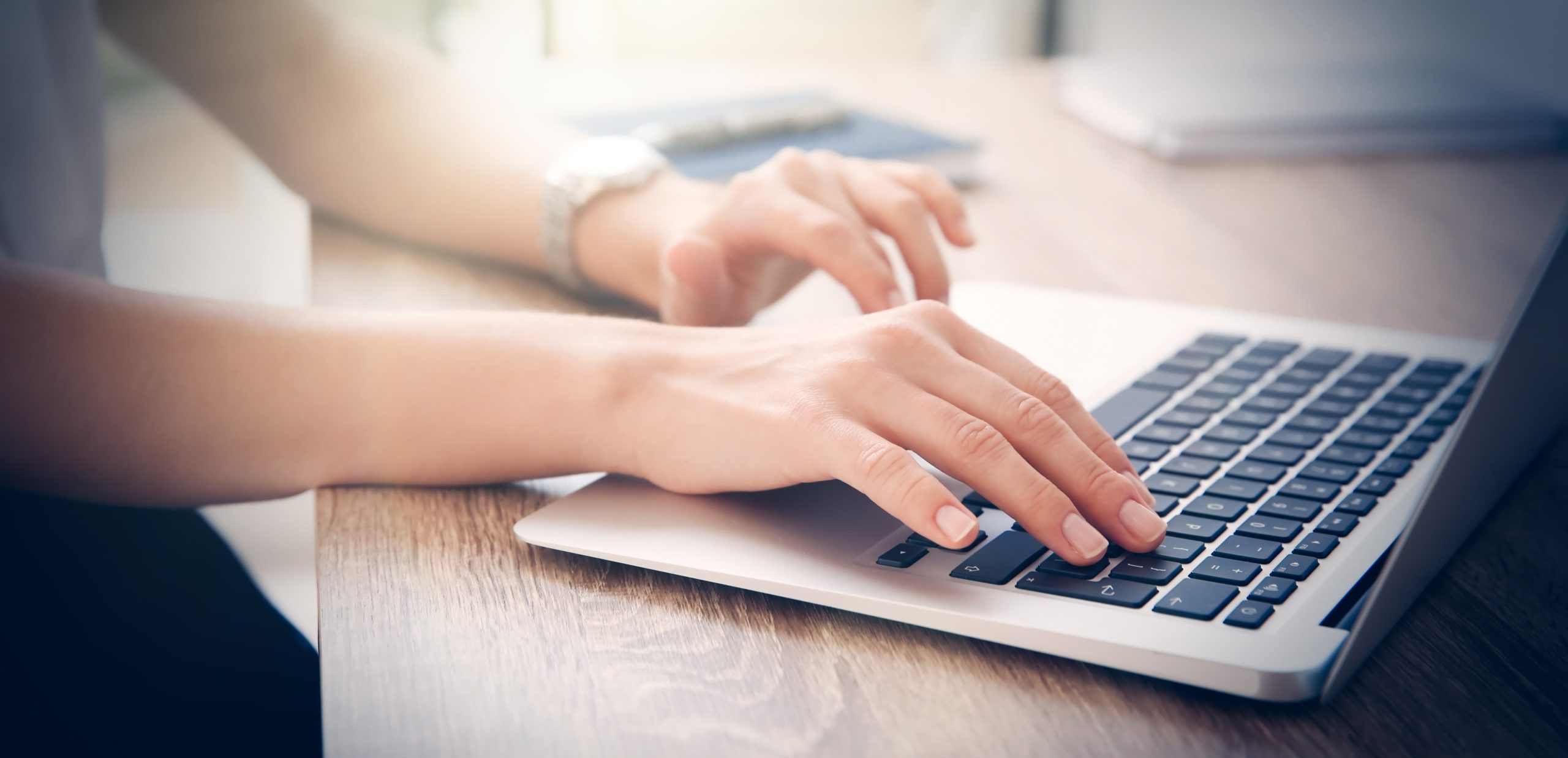 システムエンジニアのイメージ写真。ノートパソコンを操作する女性の手元のアップが写っている。